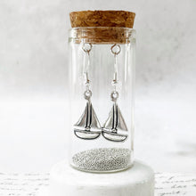 Load image into Gallery viewer, silver sailing bat earrings presented in a display bottle