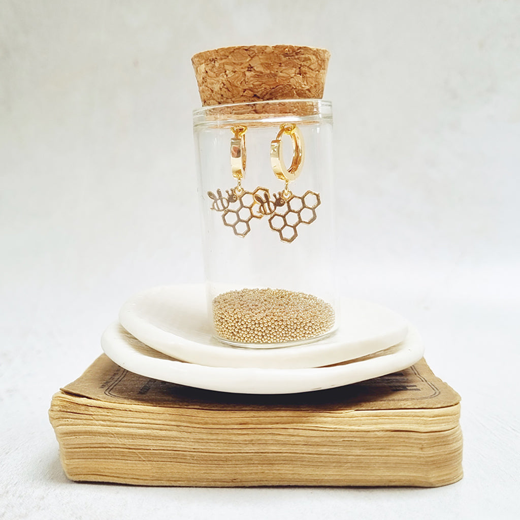 Bee and Honeycomb Gold Huggie Earrings in a bottle