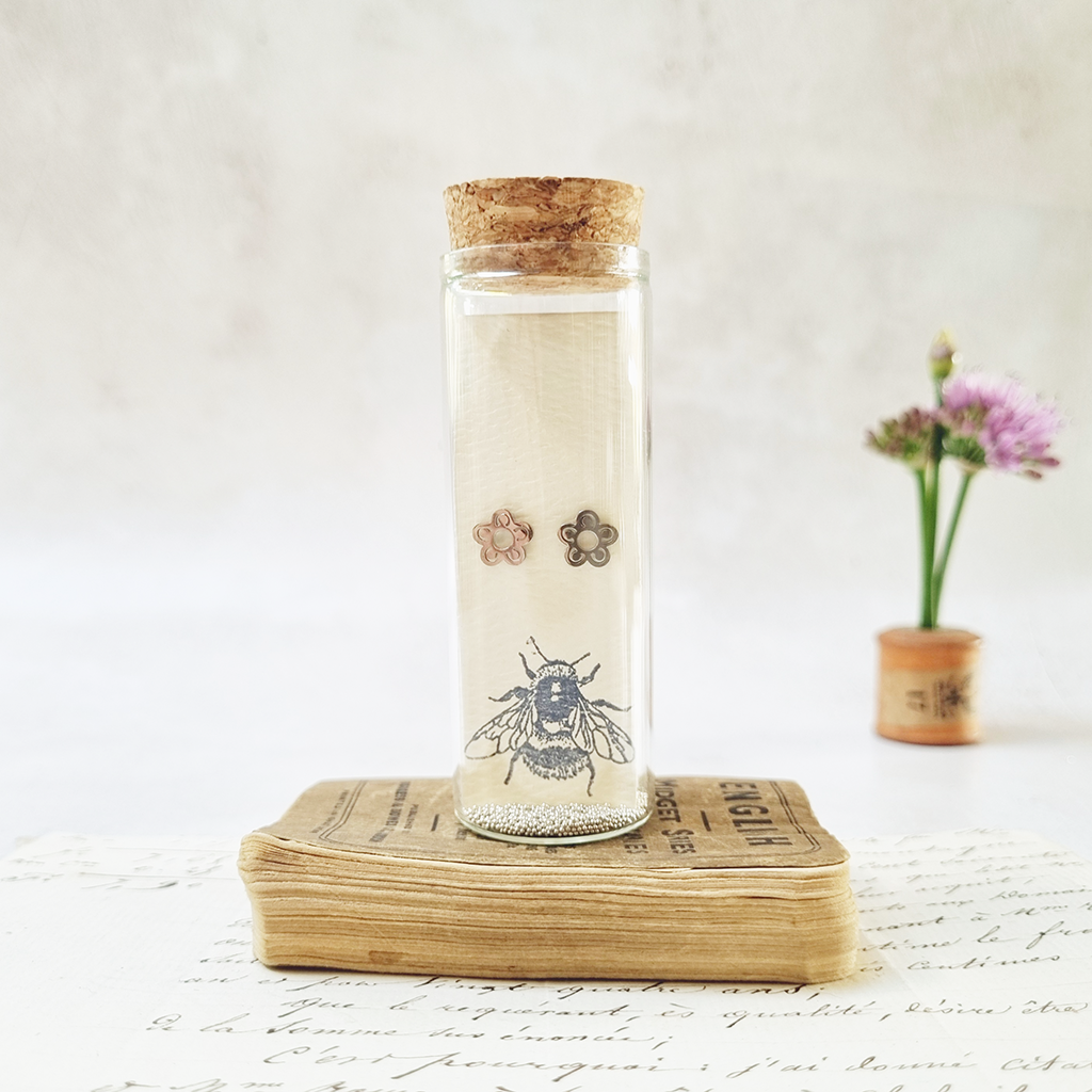 Classic daisy flower stud earrings in a bottle