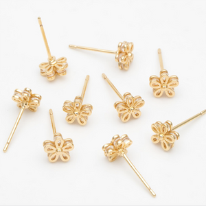 Gold flower stud earrings in a bottle