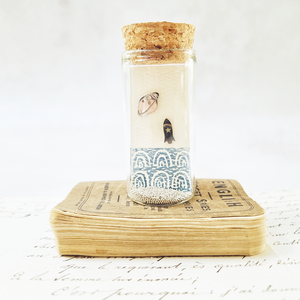 Space rocket and planet stud earrings in a bottle