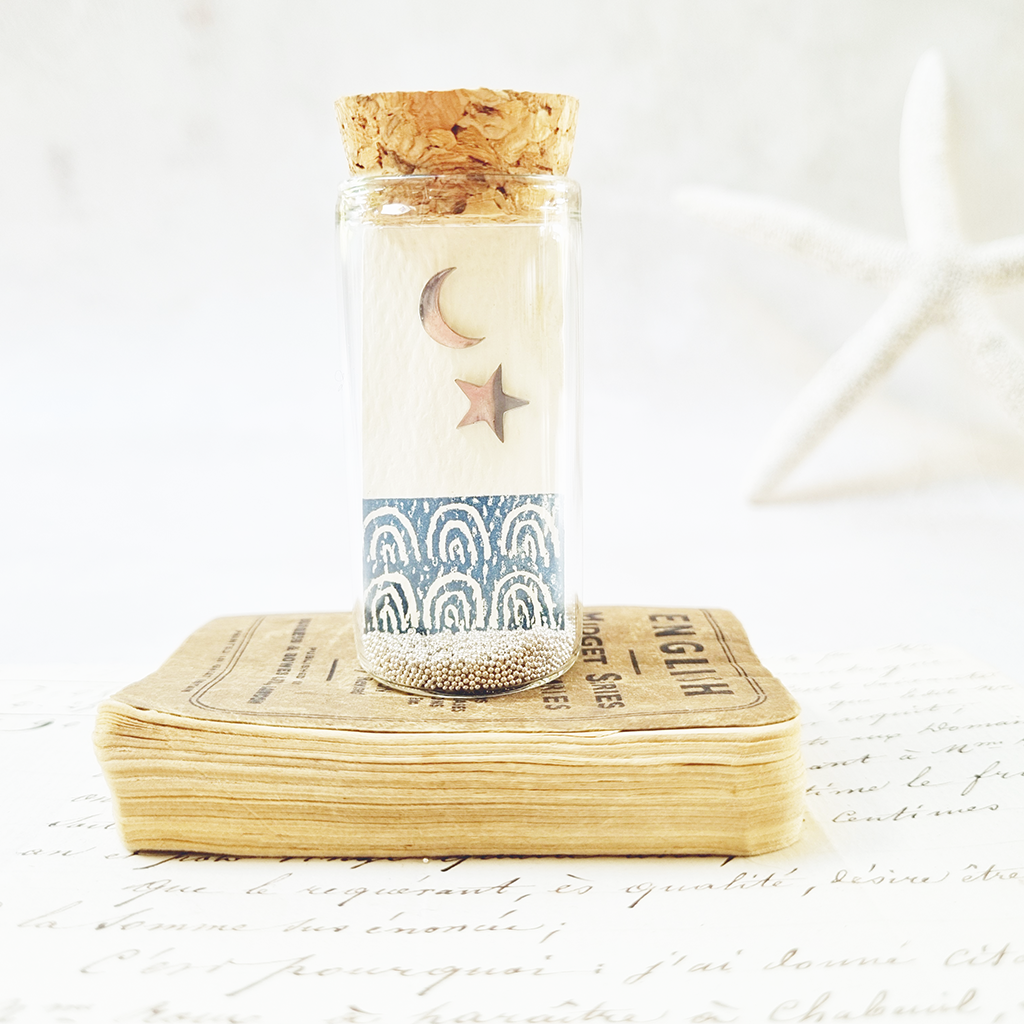 Star and moon stud earrings in a bottle